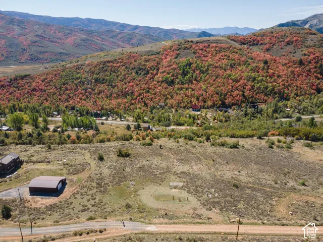Expansive property featuring a detached outbuilding, substantial land area, and mountainous scenery
