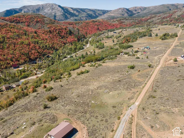 Rolling terrain with a visible road and distant mountainous backdrop