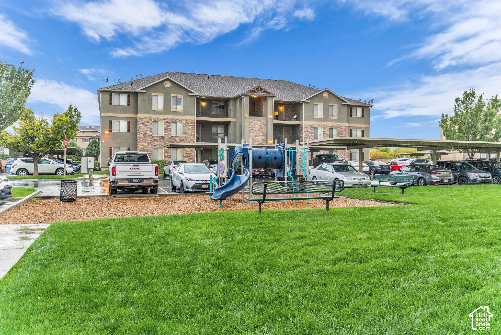 Expansive green space with an integrated playground structure.