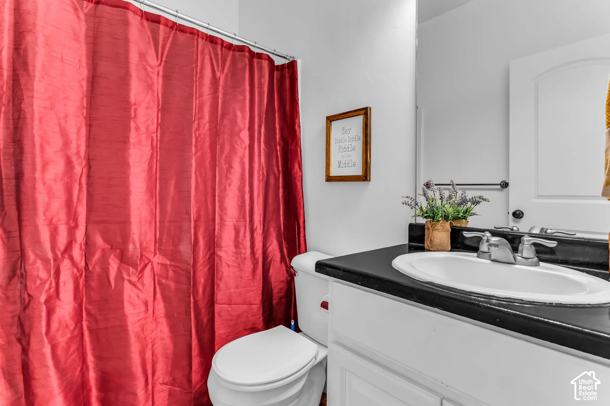 White vanity with a black countertop and an undermount sink