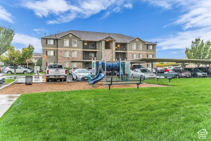 Expansive green space with an integrated playground structure.