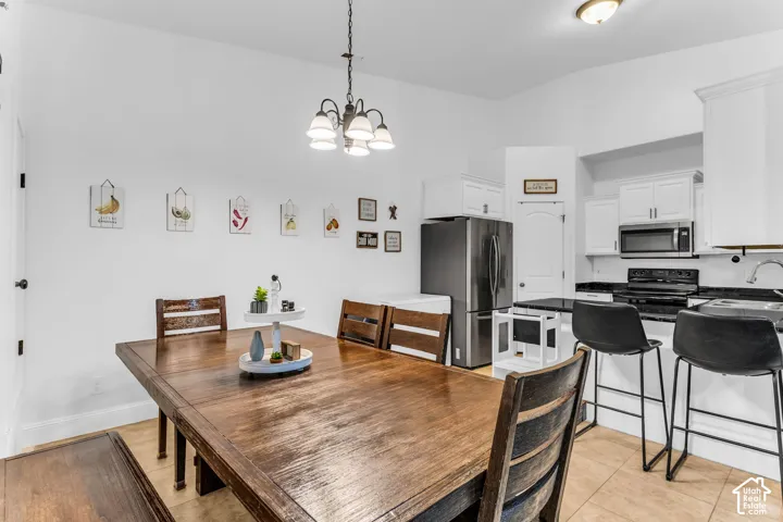 Open-concept kitchen and dining area featuring a dark wood-finish dining table and tile flooring
