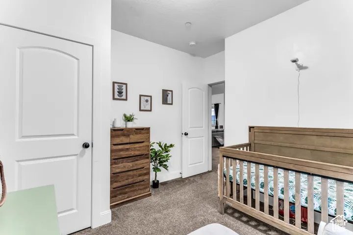 White interior doors with arched top panels, neutral carpet flooring, and white painted walls