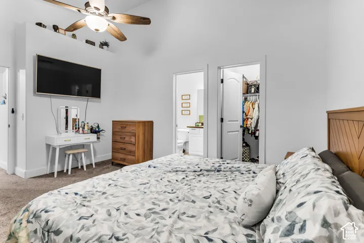 Vaulted ceiling with a ceiling fan, wall-mounted television, and a wood-finish headboard