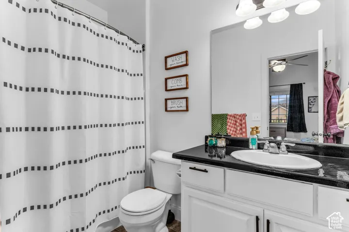 White vanity with dark countertop and an undermount sink