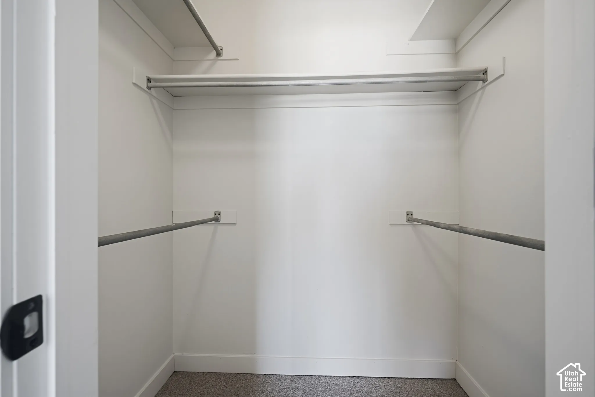 Functional closet space featuring multiple hanging rods and light-toned walls