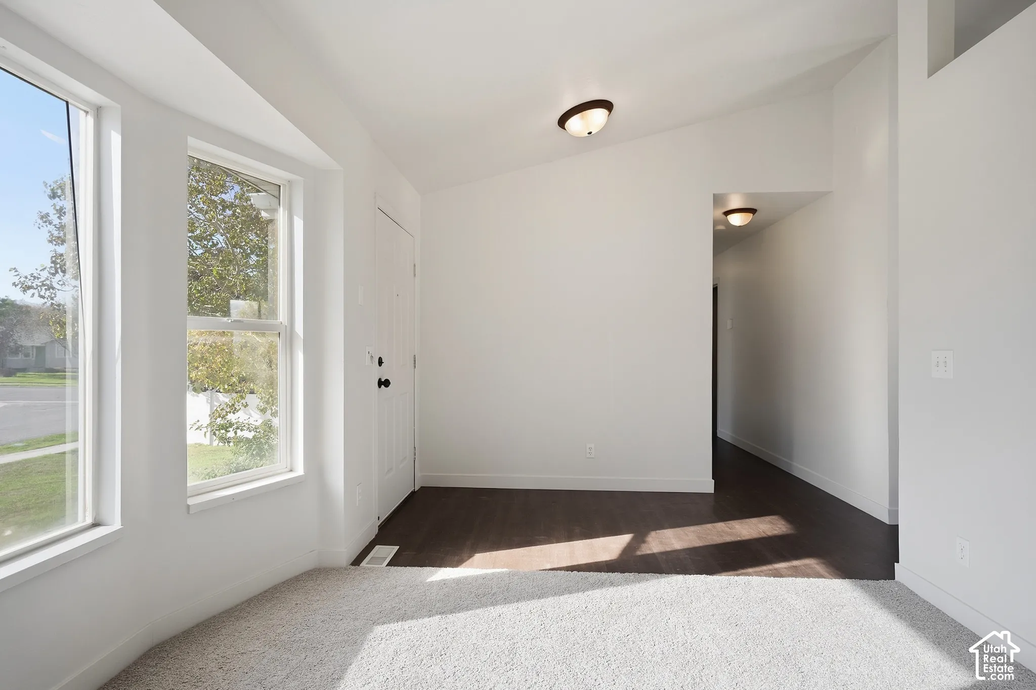 Bright interior with multiple windows and a front entry door