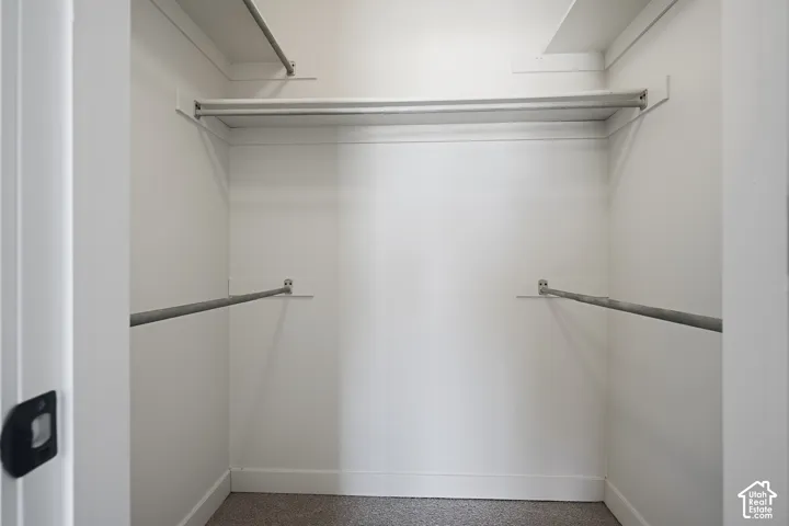 Functional closet space featuring multiple hanging rods and light-toned walls