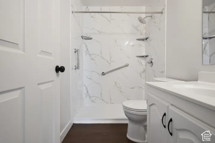 Walk-in shower with marble-look surround, integrated shelving, and chrome fixtures
