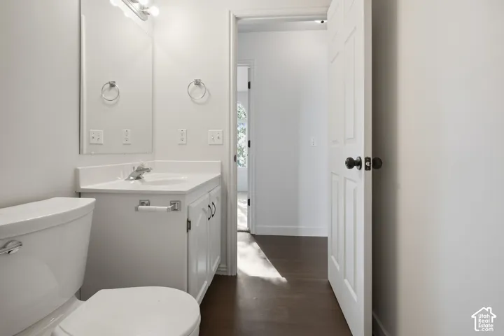 White vanity with an integrated sink and countertop, polished chrome faucet, and overhead vanity lighting