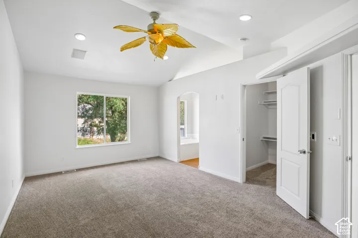 Vaulted ceiling with recessed lighting and a ceiling fan
