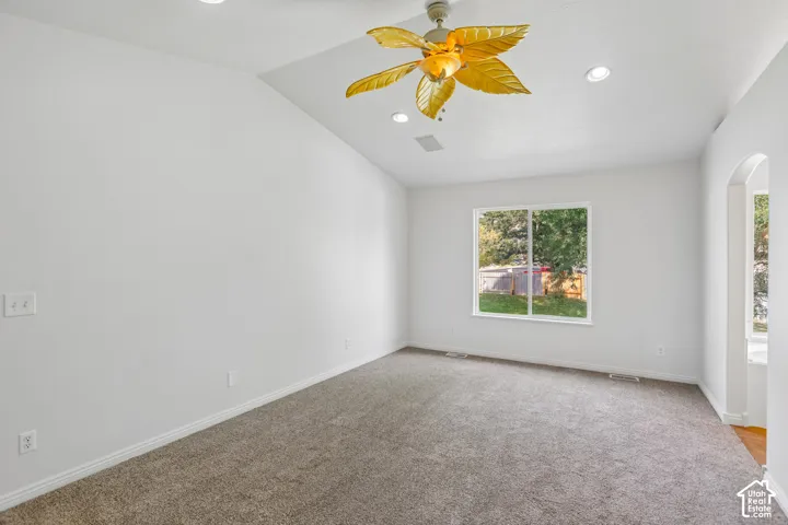 Vaulted ceiling with recessed lighting and a unique ceiling fan