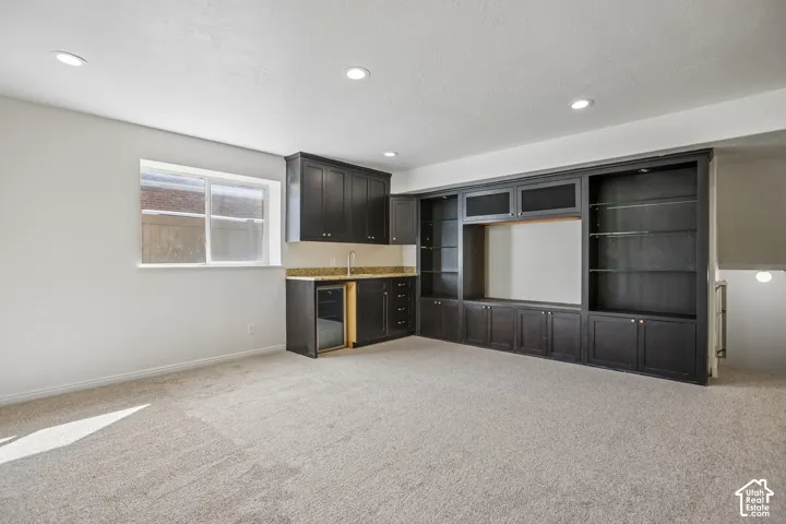 Built-in media center with shelving, recessed lighting, and wall-to-wall carpeting