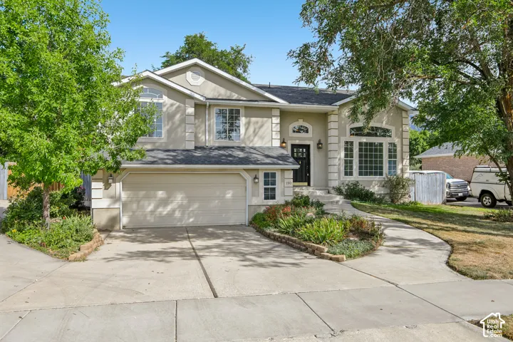 Stucco exterior with decorative trim, arched windows, and a black front door