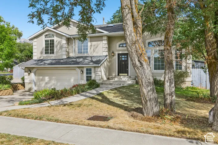 Stucco exterior with decorative trim, arched entry window, and an attached two-car garage
