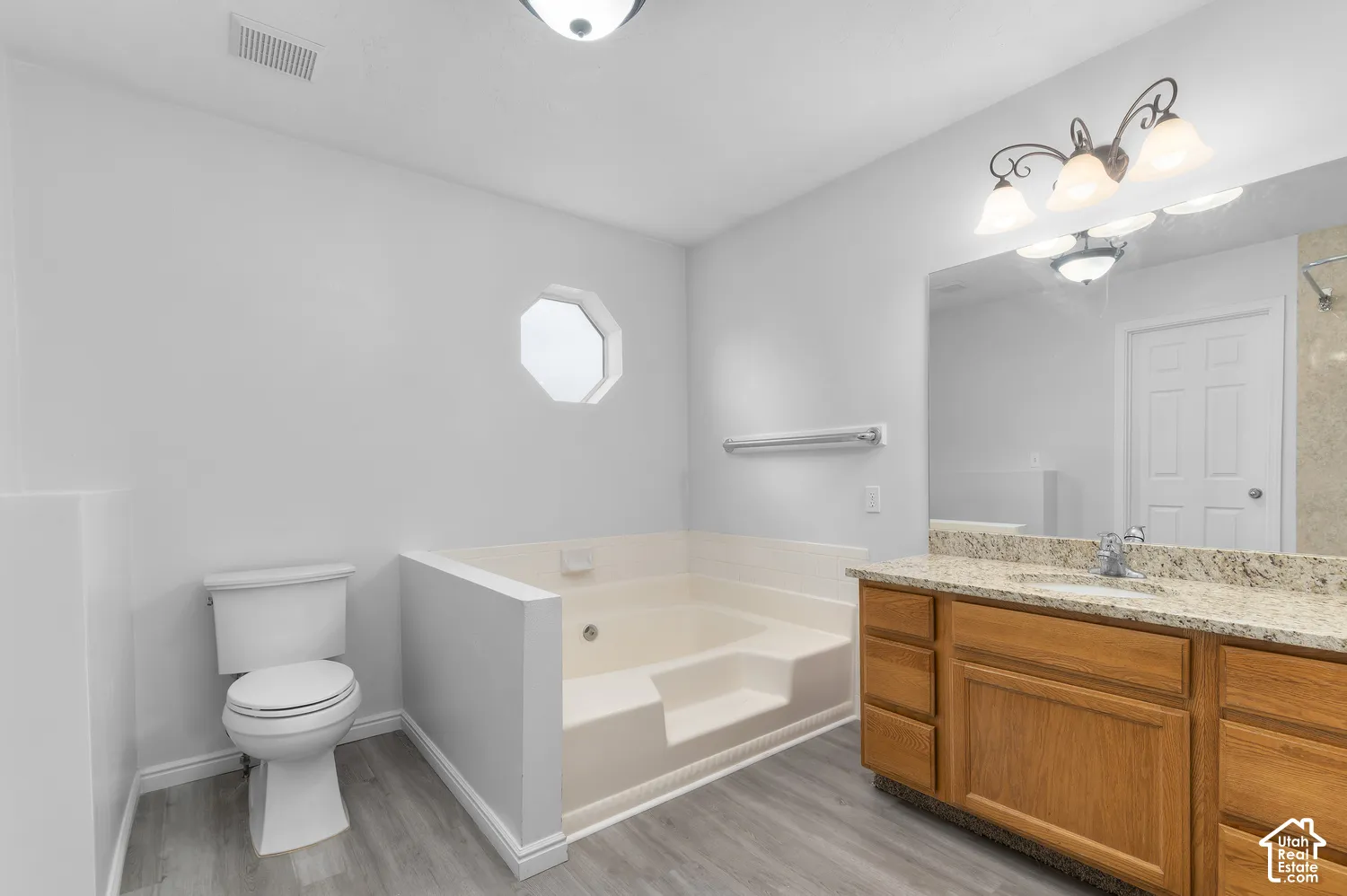 Primary Suite bath with separate tub/shower. Granite countertops. Fun hexagon window