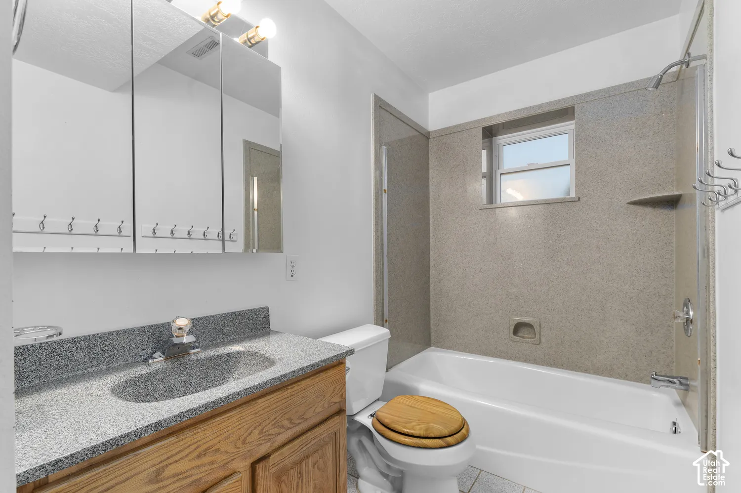 Full bathroom in the basement with new granite countertop and shower surround