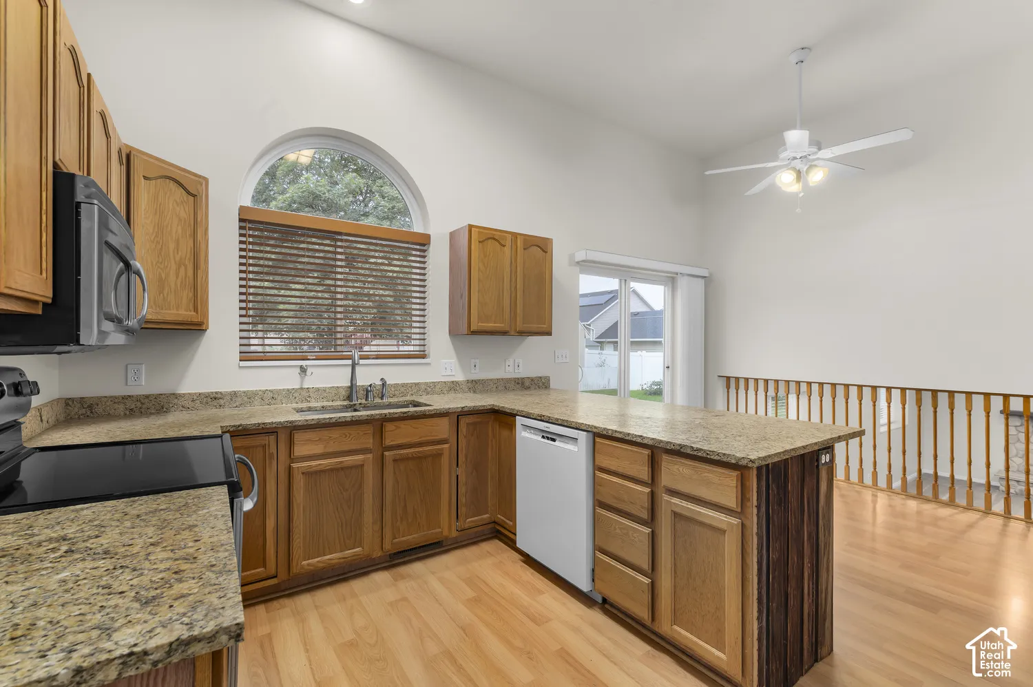 Kitchen featuring wood-finish cabinetry, granite countertops, and newer appliances