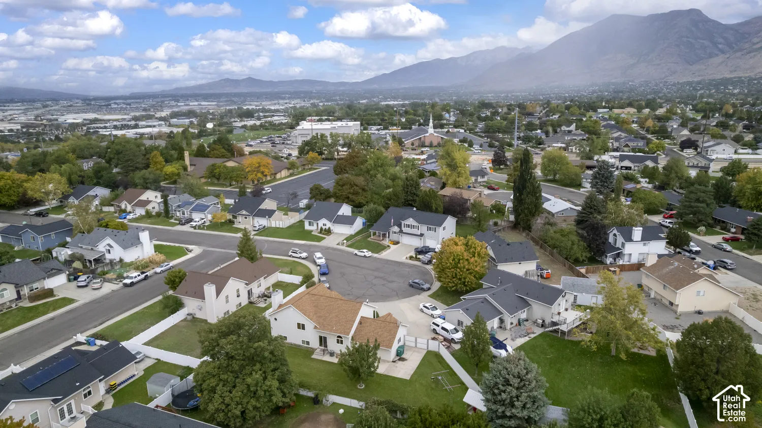 Residential neighborhood with established streets and mature trees, featuring a distant mountain range