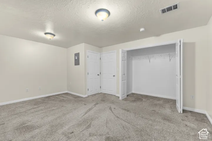 Wall-to-wall carpeting with light-toned walls, bi-fold closet doors, and flush-mount ceiling lighting