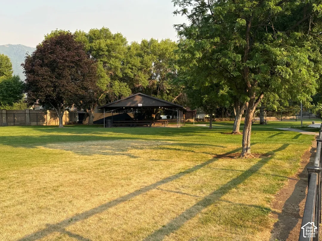 At park next door, Expansive grassy area with mature trees and a covered pavilion