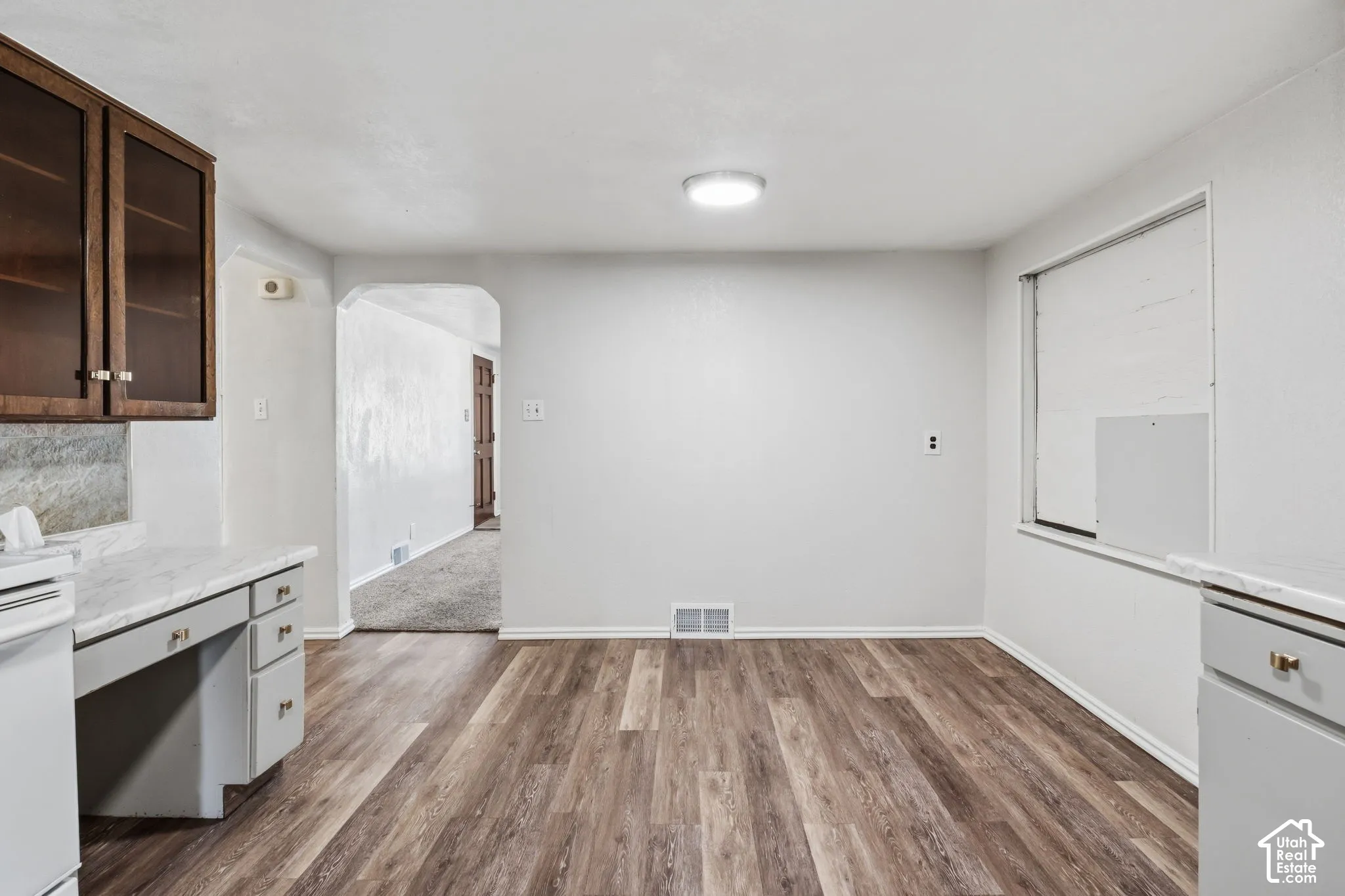 Laminate flooring with white baseboards and light gray walls