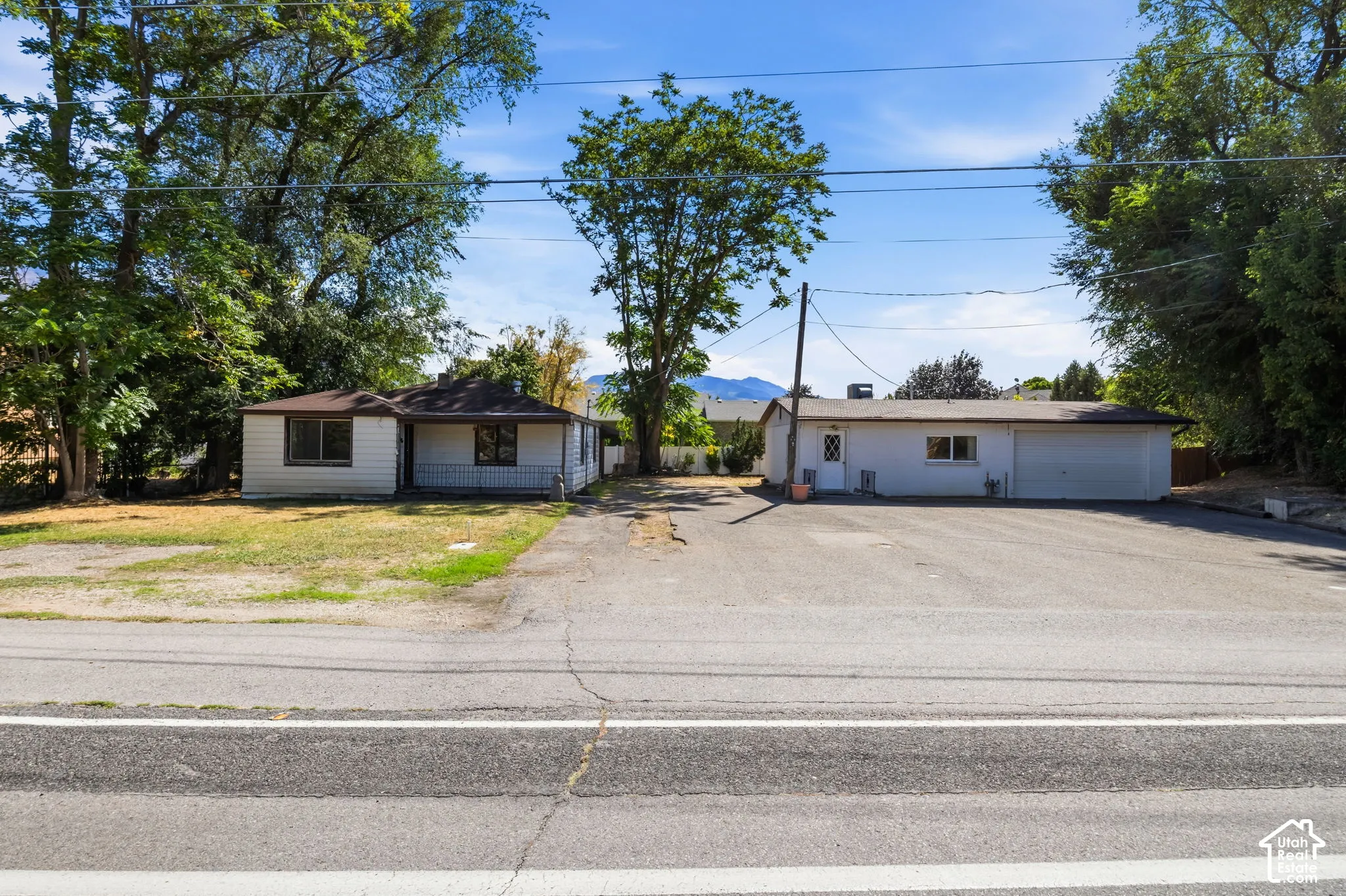 Two distinct structures with separate paved parking areas, set among mature trees