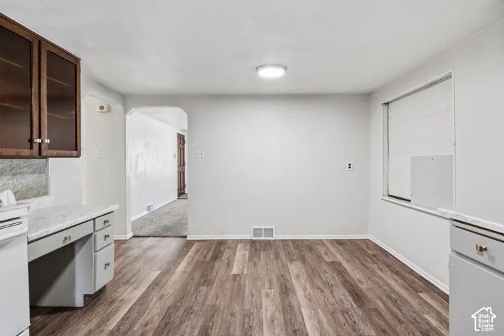 Laminate flooring with white baseboards and light gray walls