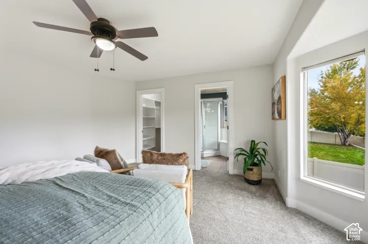 White walls, light gray carpet, and a ceiling fan with integrated lighting