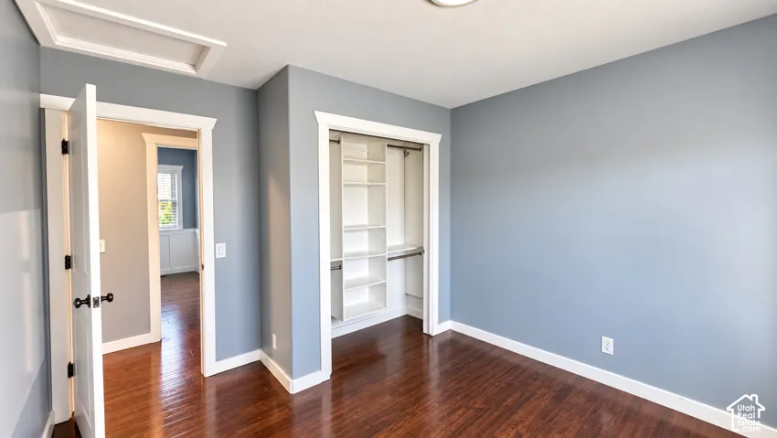 Hardwood-finish flooring, built-in closet shelving, and a flush-mount ceiling light fixture
