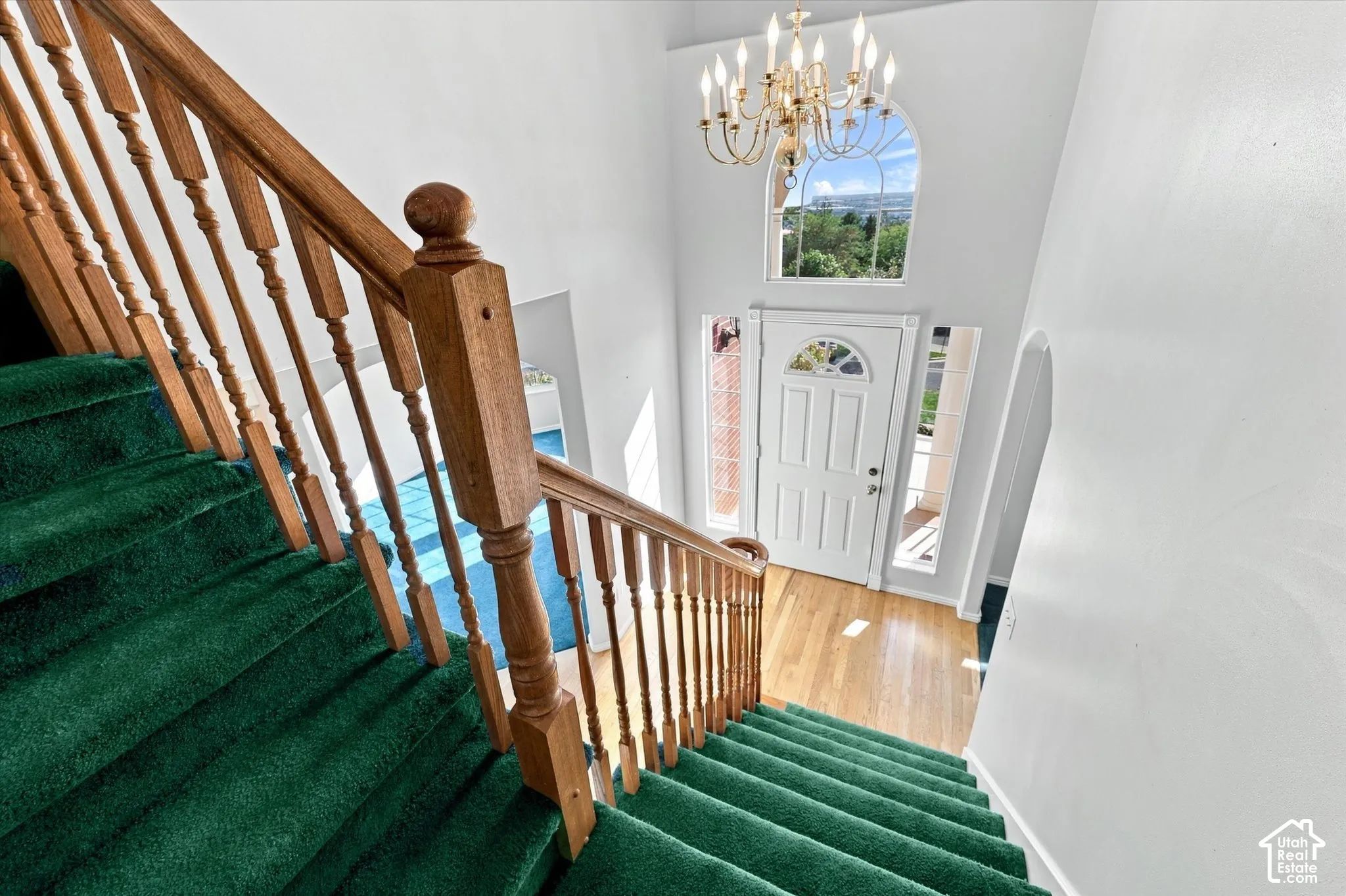 Two-story foyer with a decorative chandelier and arched transom window