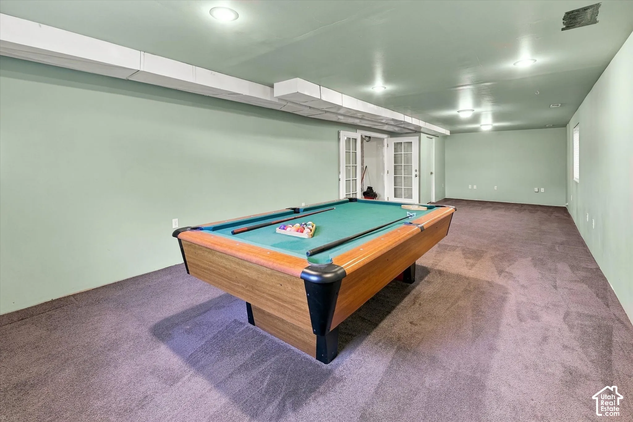 Spacious room with recessed lighting and neutral carpeting