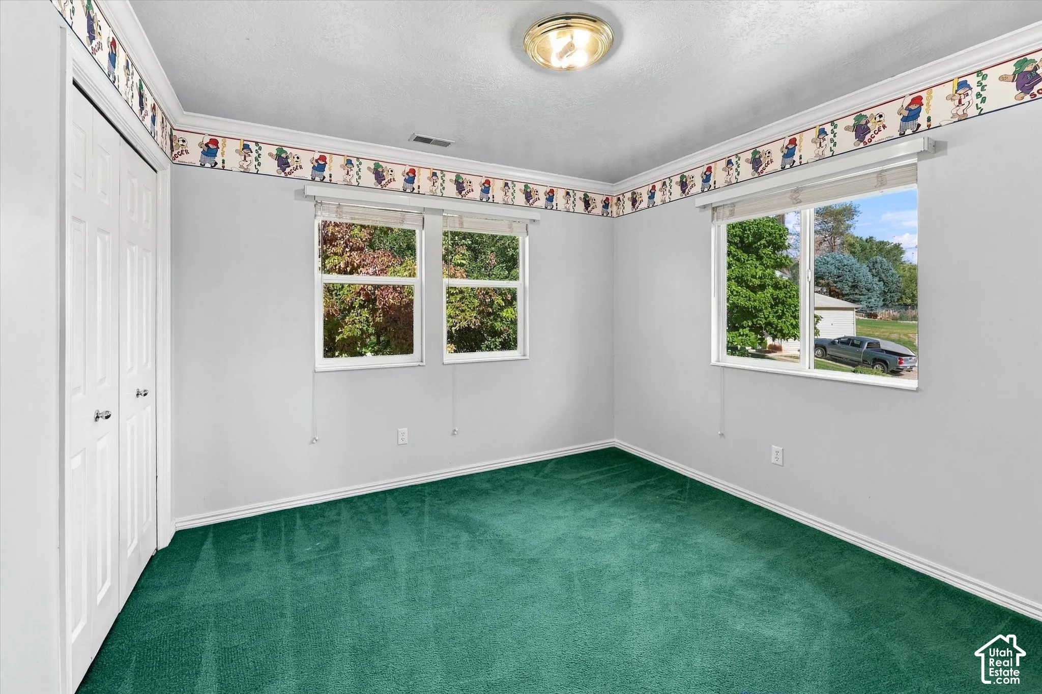 Bright room with green carpeting, white trim, and multiple windows