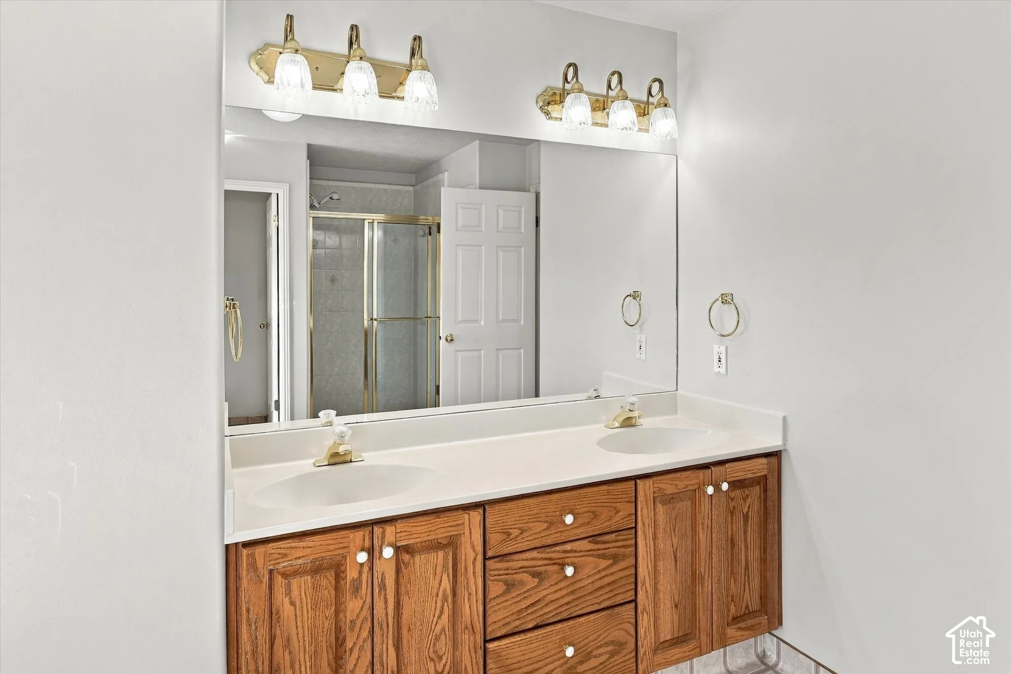 Dual vanity with integrated sinks, white countertop, and wood-finish cabinetry