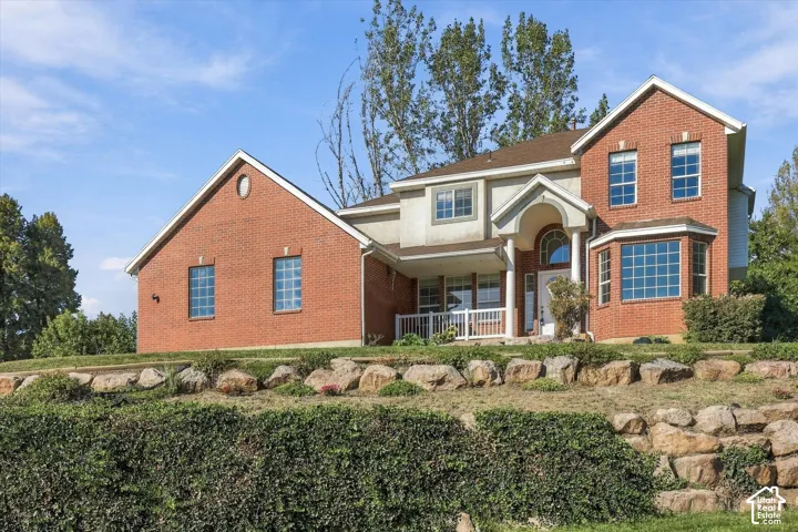 Brick exterior with a gabled roofline, bay window, and covered porch with white columns