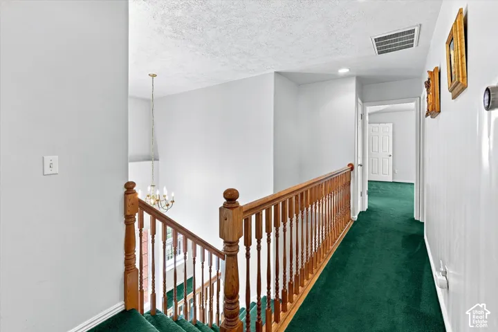 Upper-level hallway with wood railing and green carpeting
