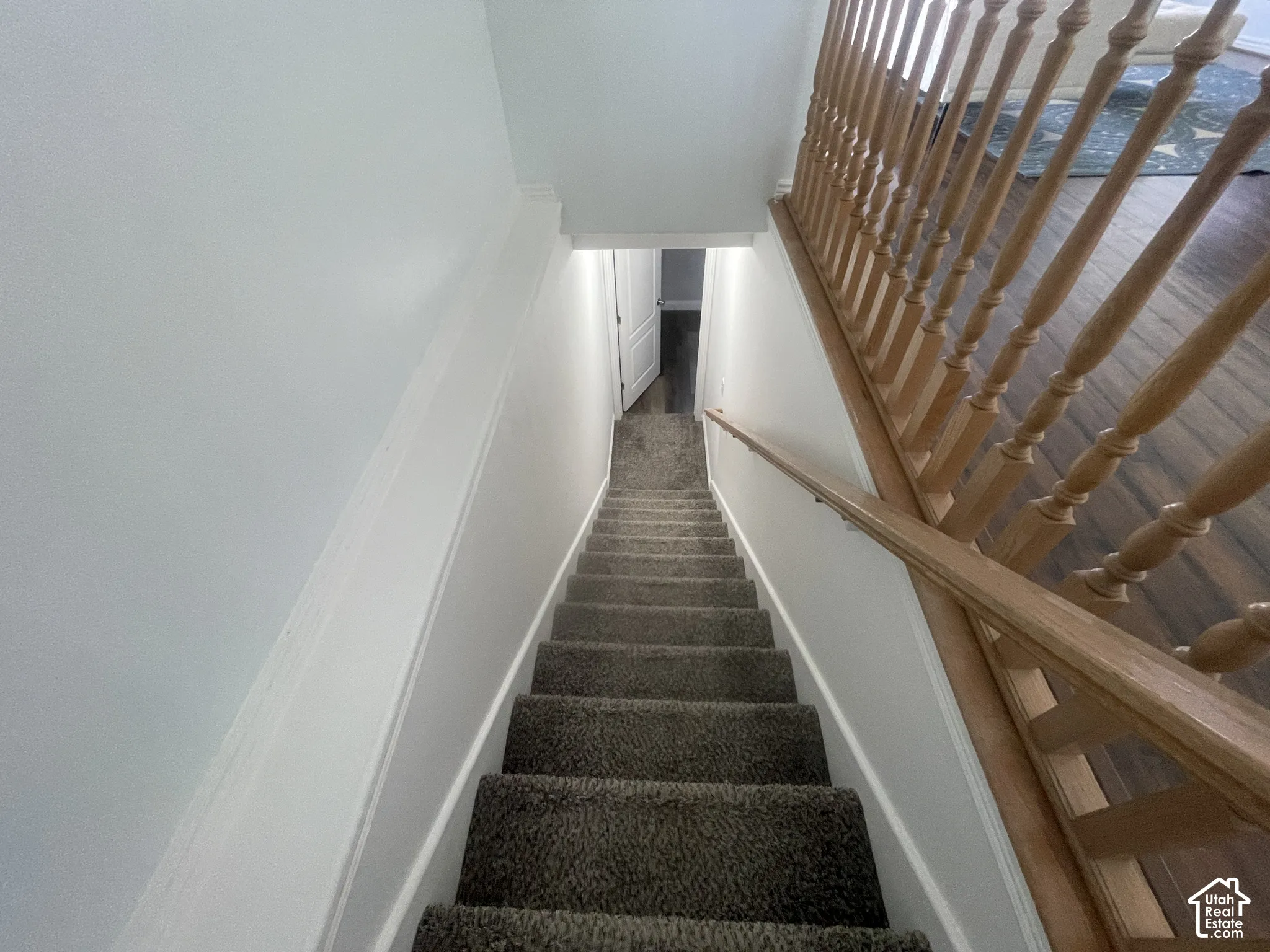 Carpeted staircase with wood-finish balusters and handrail