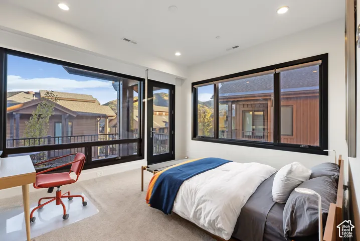 Wall-to-wall carpeting and large windows with black frames