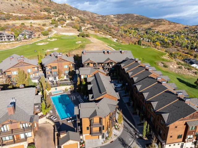 Community featuring a large outdoor swimming pool, integrated spa, and surrounding paved patio