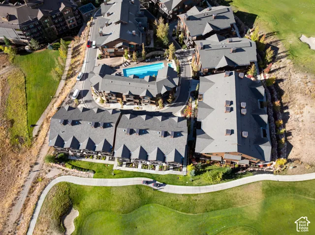 Community with multiple buildings featuring gabled roofs, an outdoor swimming pool, and dedicated pathways