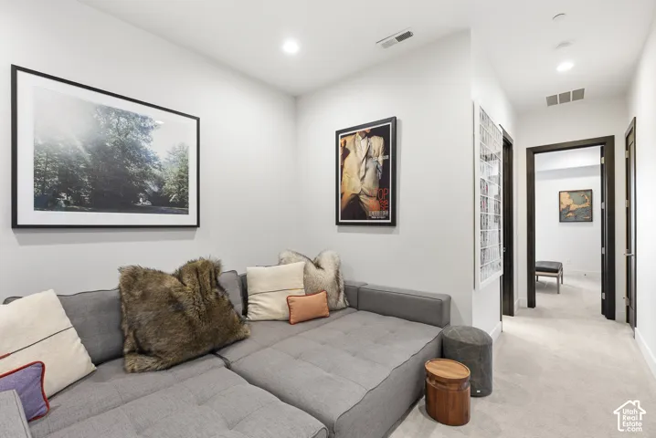 Recessed ceiling lighting, neutral wall finishes, dark-trimmed doorways, and light-toned carpeting