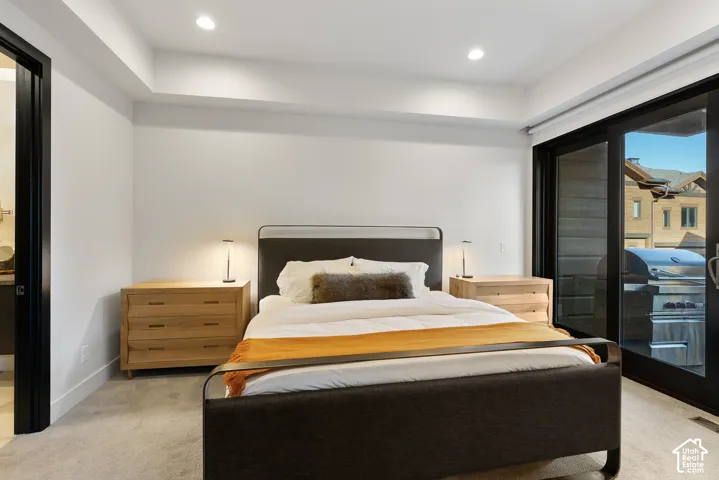 Recessed ceiling lighting, light-toned wall finishes, carpeted flooring, and glass sliding doors