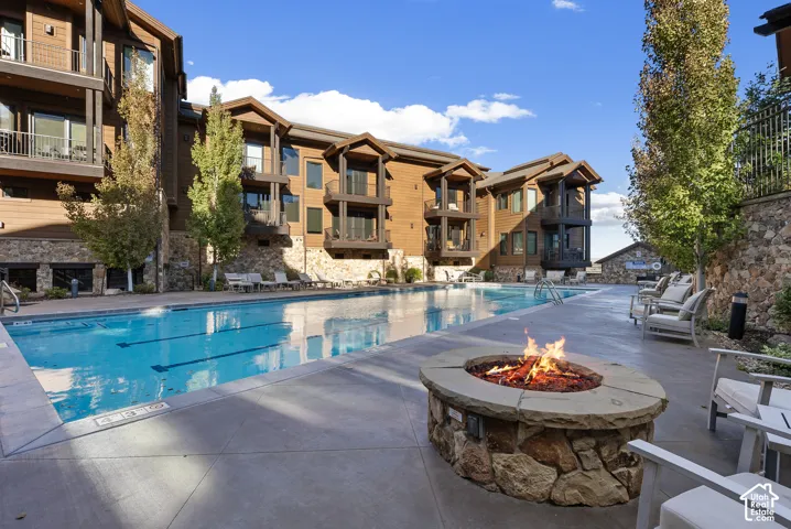 Expansive outdoor pool with integrated swim lanes, complemented by a stone-clad fire pit