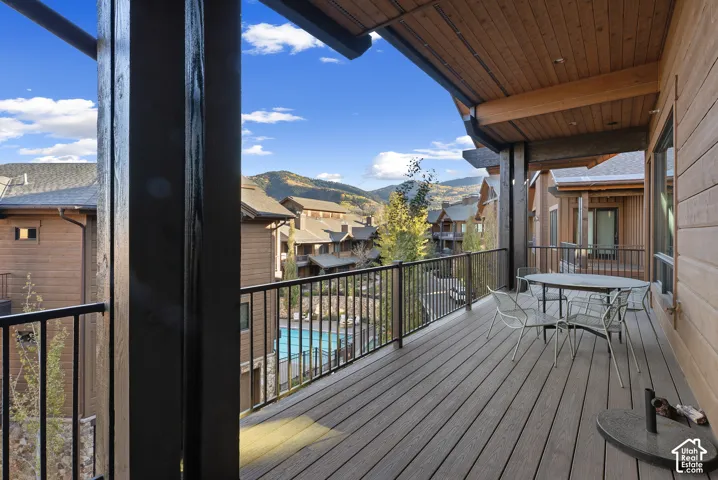 Elevated composite deck with metal railings overlooking the community pool and surrounding mountain landscape