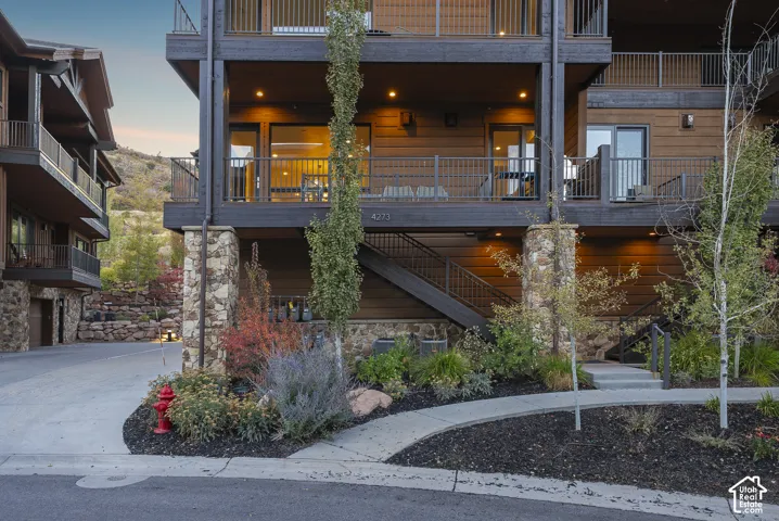 Multi-level exterior with dark wood siding and stone accents
