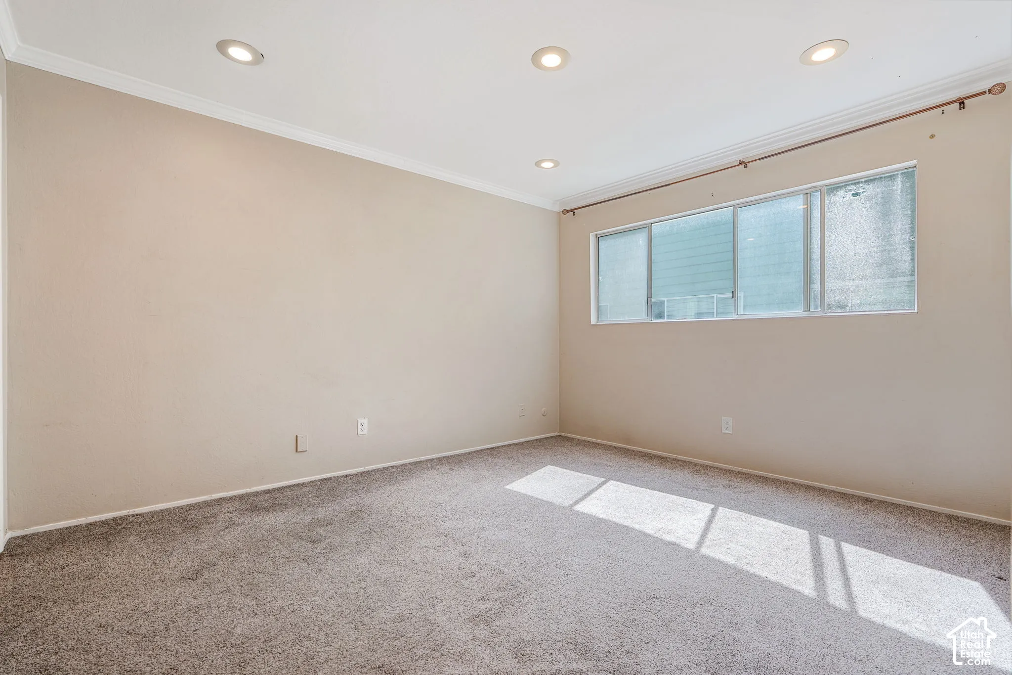 Recessed lighting, crown molding, and neutral wall paint