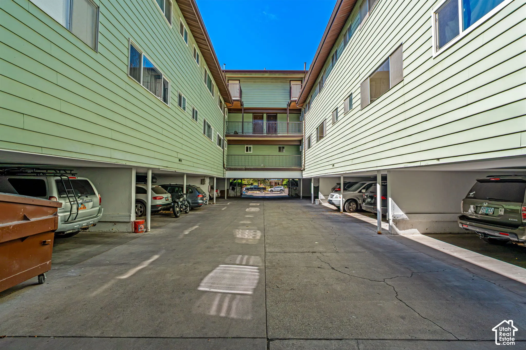 Covered parking area with concrete flooring, supported by structural columns