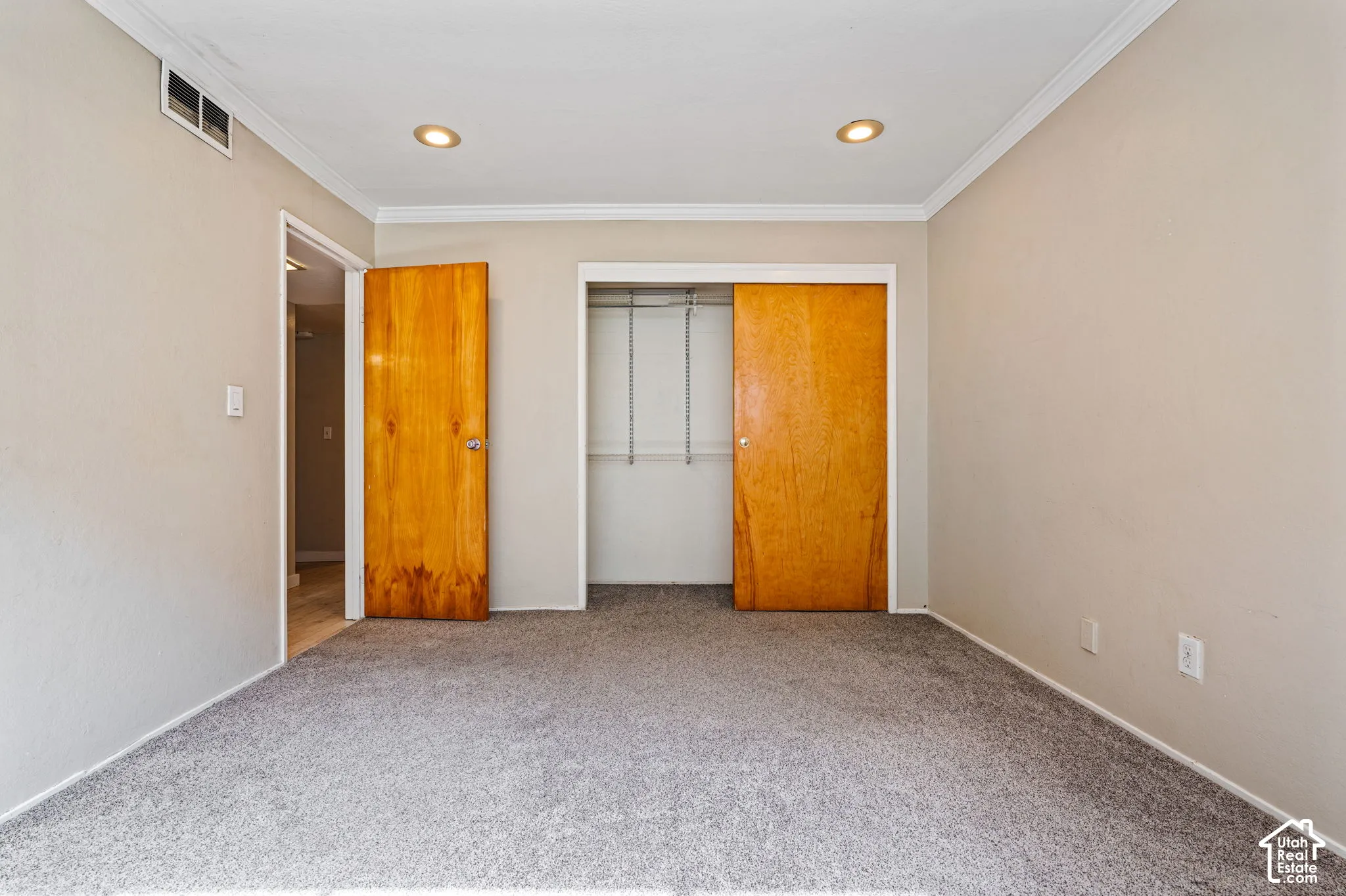 Gray carpeting with neutral-toned walls, recessed lighting, and crown molding