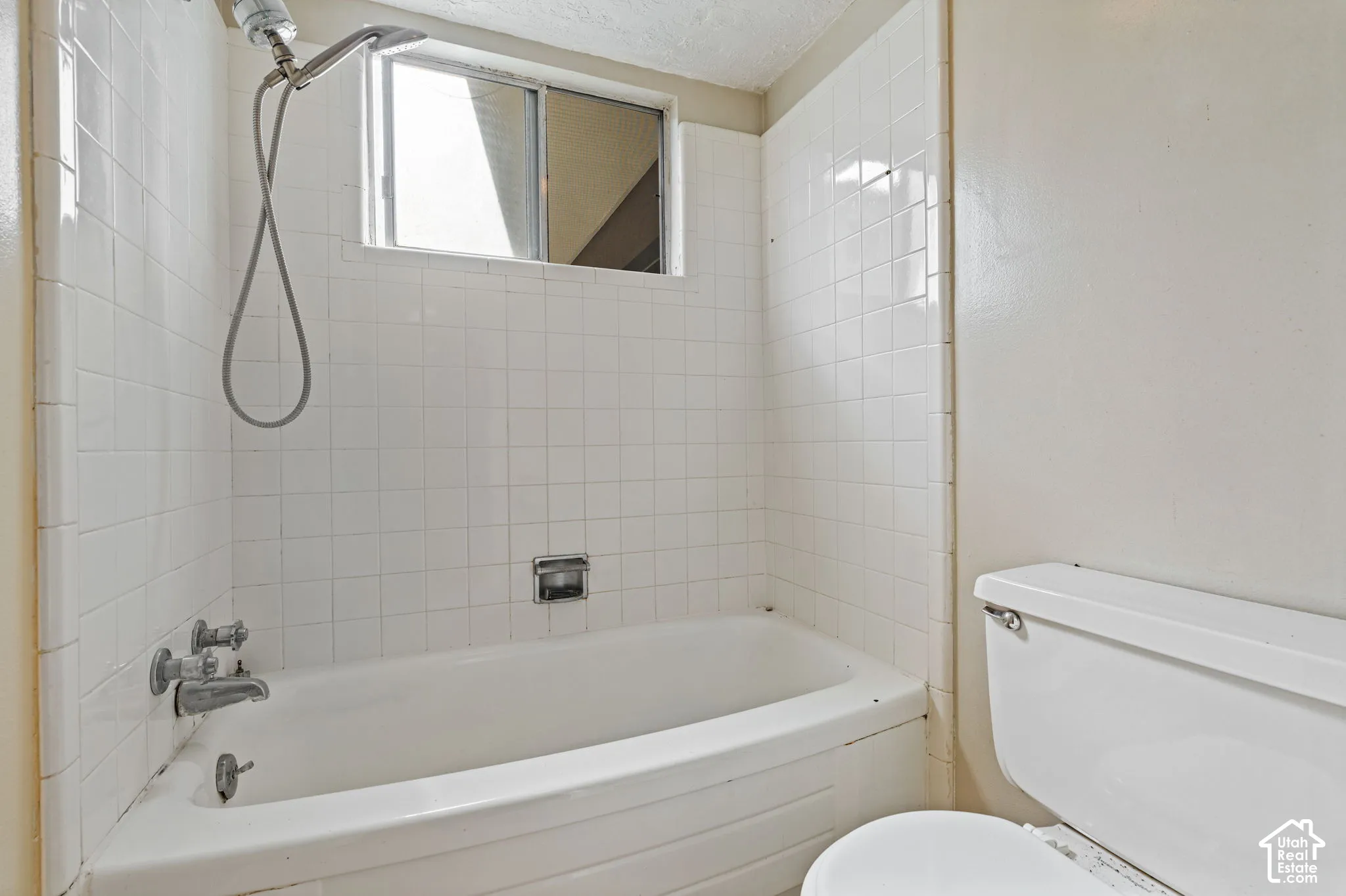 Tub and shower combination with white tile surround