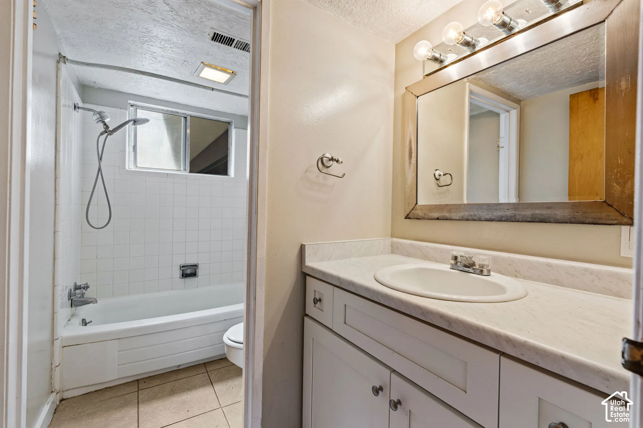 Vanity with undermount sink, white cabinetry, and light-toned countertop